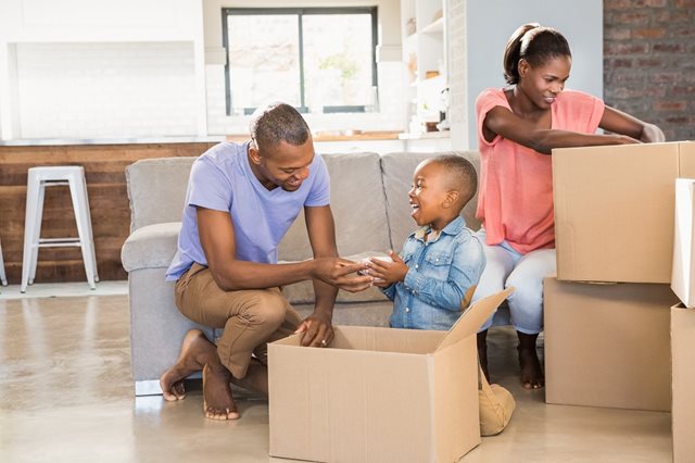 Family unpacking moving boxes